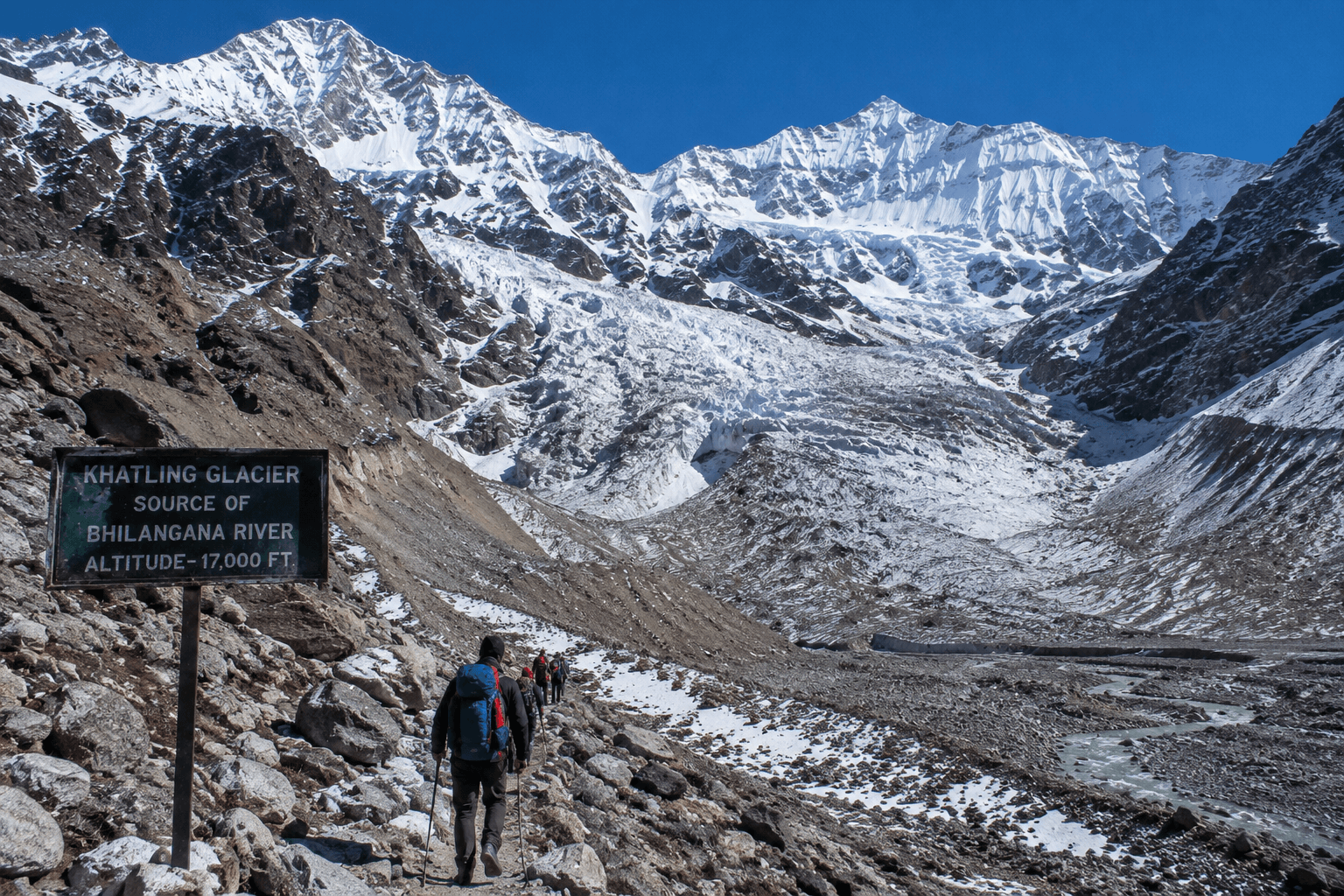 Trekkers walking towards Khatling Glacier surrounded by snow-covered Himalayan peaks in Uttarakhand.